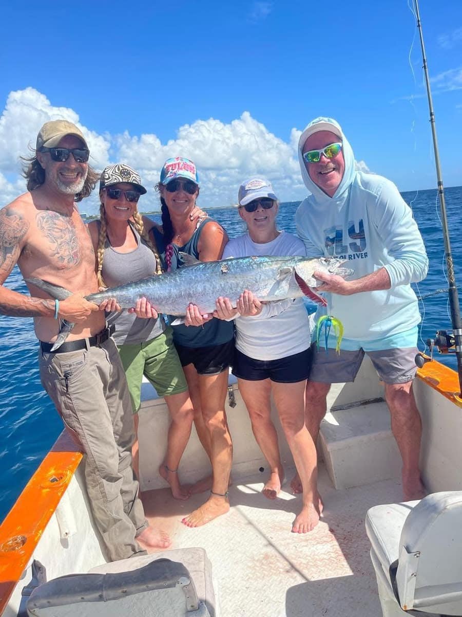 Fishing group celebrating a catch on a private charter in Akumal