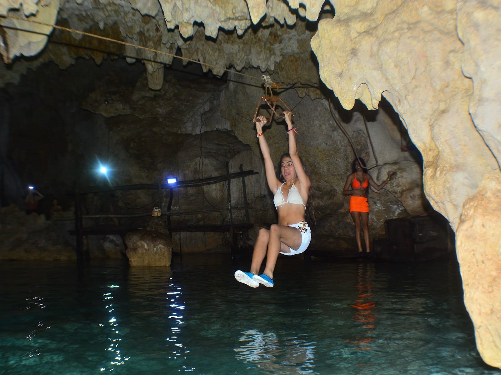 Tirolesa sobre el agua turquesa dentro de la caverna del Cenote Alux