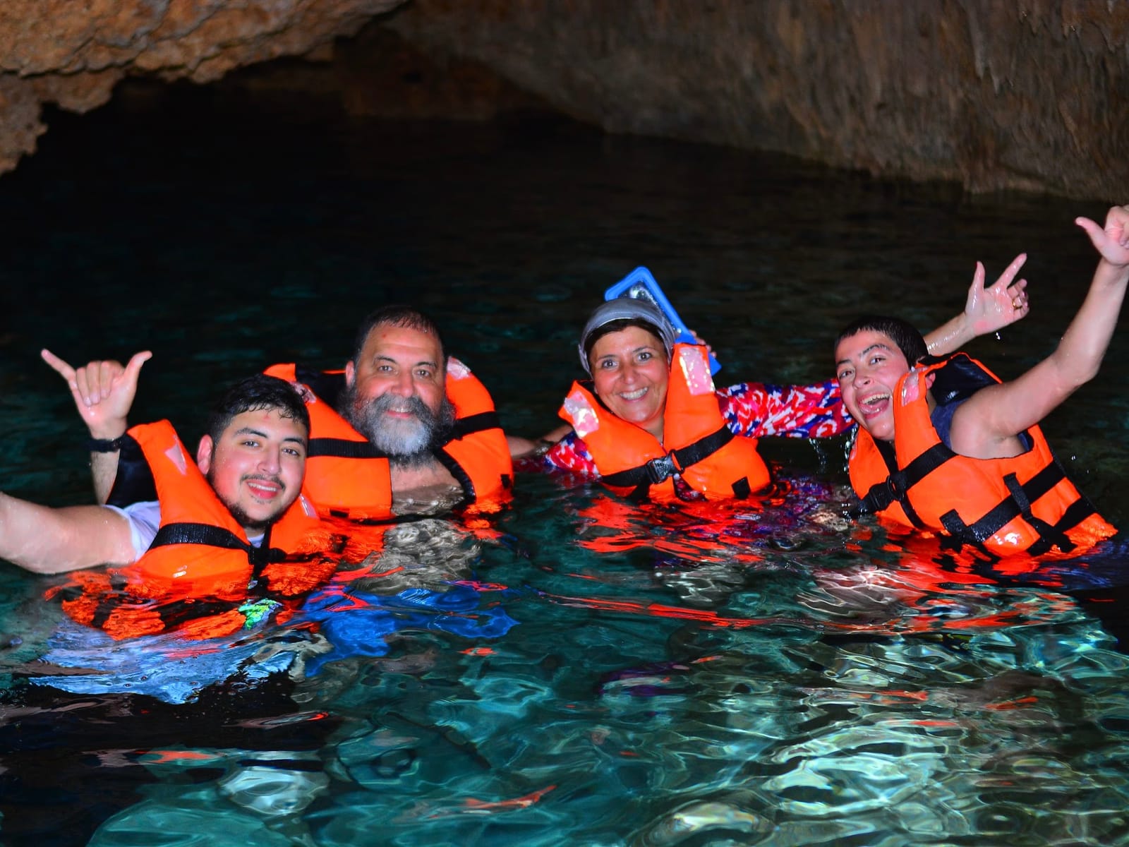 Grupo con chalecos salvavidas nadando en el Cenote Alux