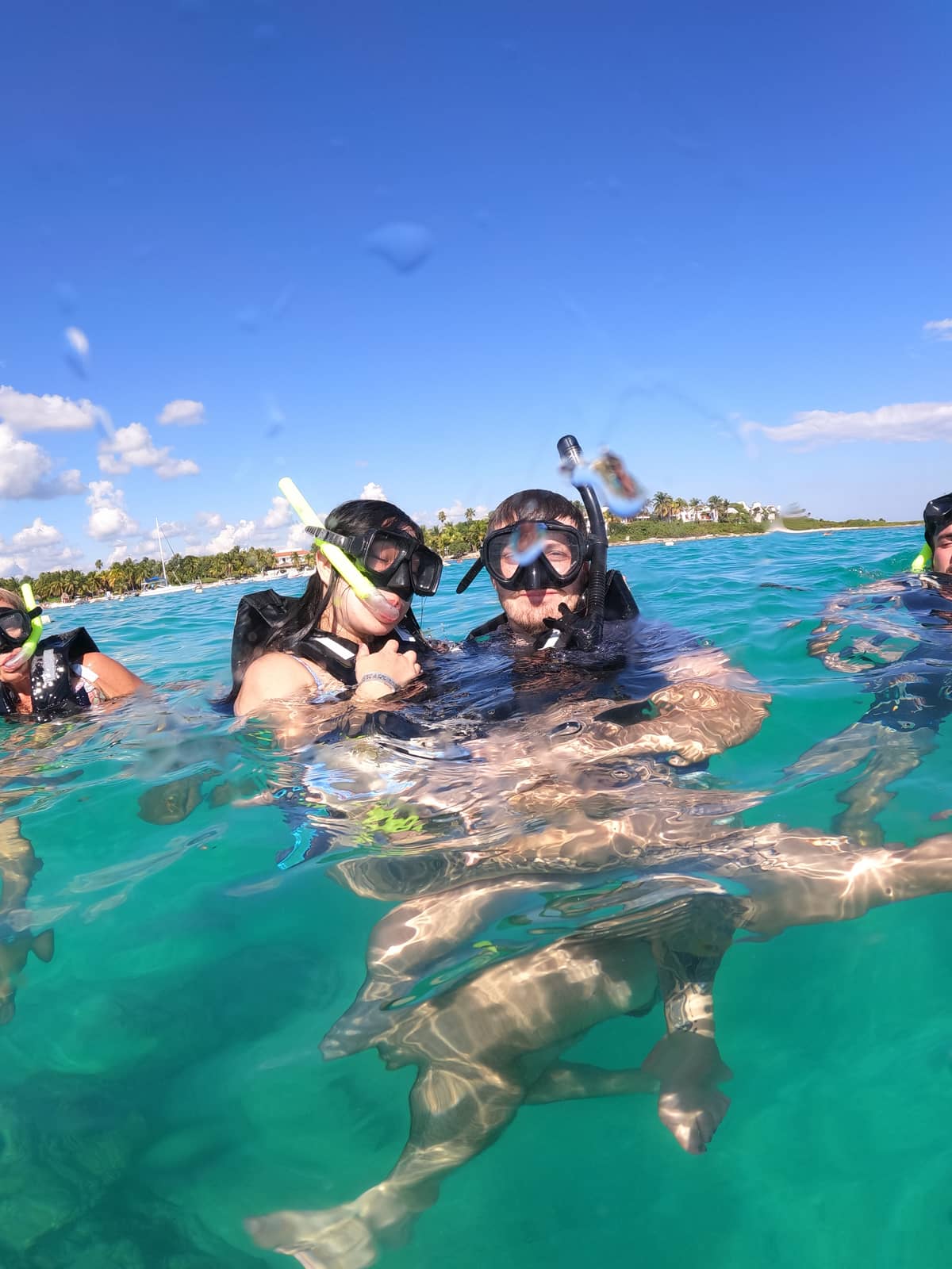 Couple snorkeling beside a sea turtle in turquoise Akumal Bay