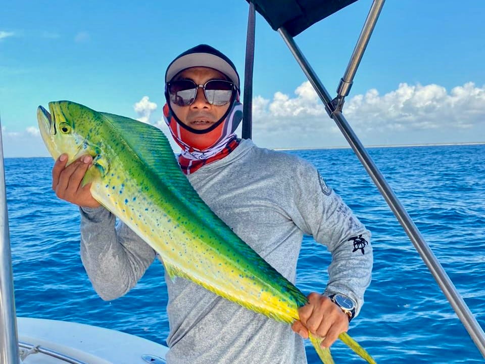 Miembro de la tripulación con un dorado recién capturado a bordo