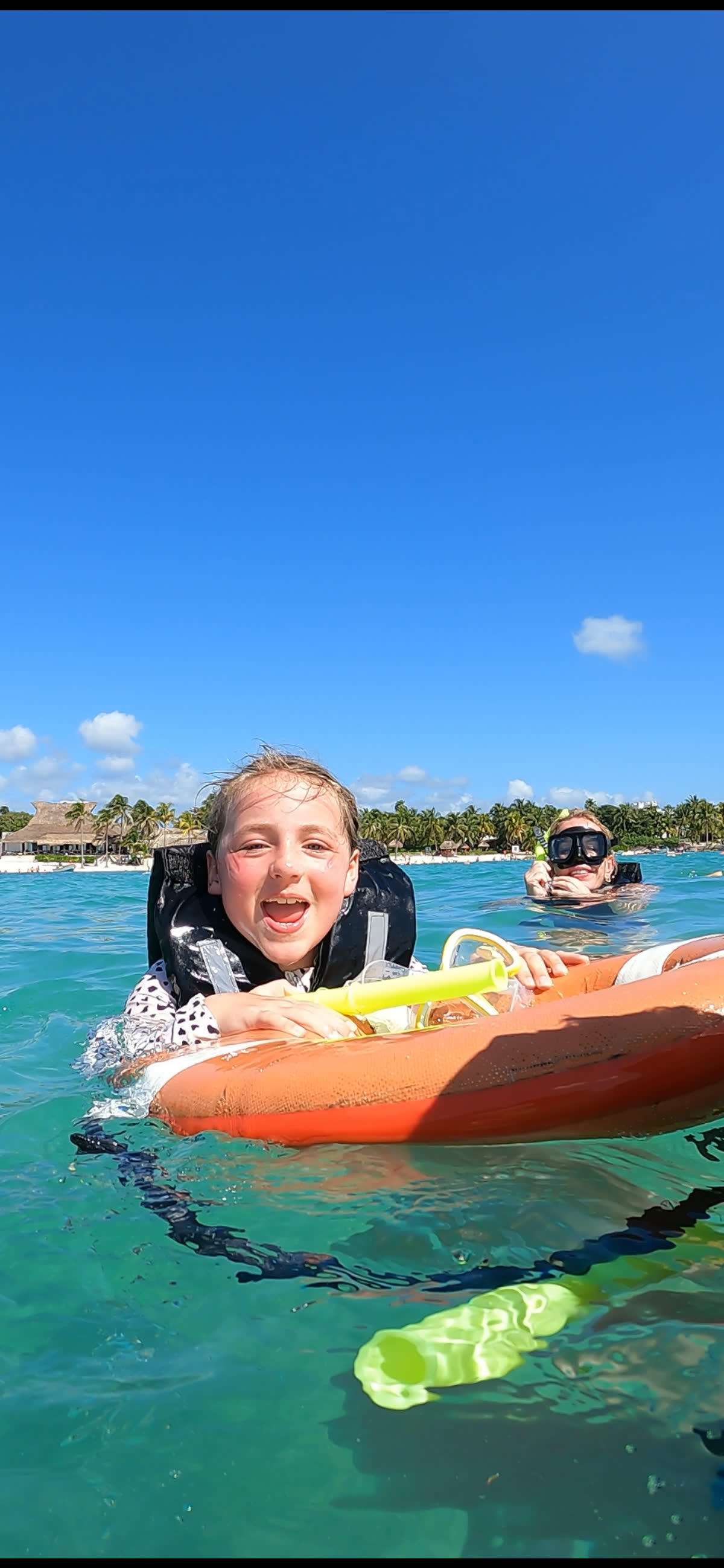 Woman snorkeling in crystal-clear turquoise waters of Akumal Bay, Mexico