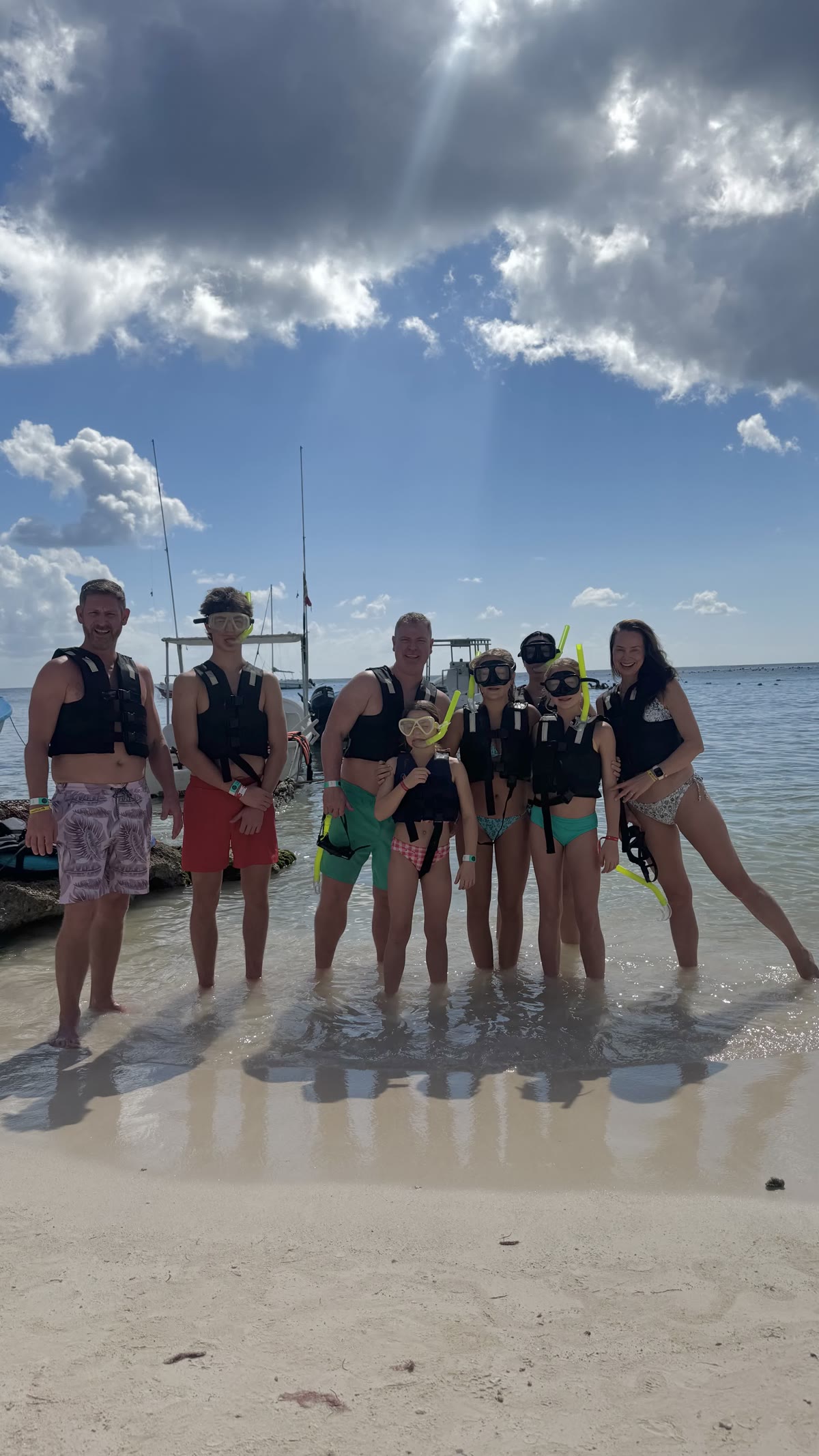 Family group of 7 with snorkel masks and life vests on Akumal Bay beach — Akbay Tours