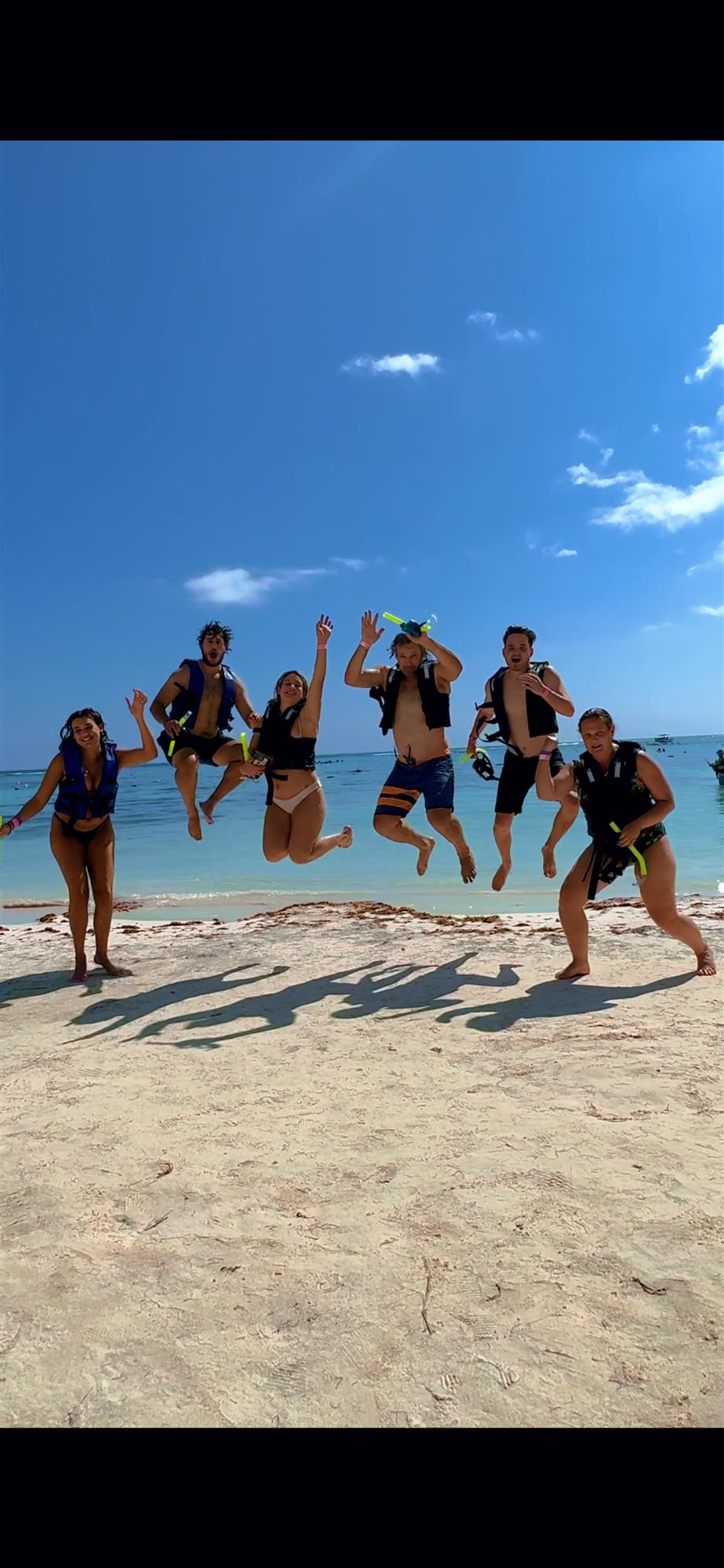 Excited guests leaping from the beach at the start of their Akumal snorkel tour