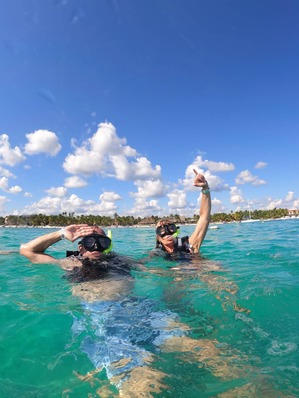 Two snorkelers celebrating after swimming with sea turtles in Akumal Bay