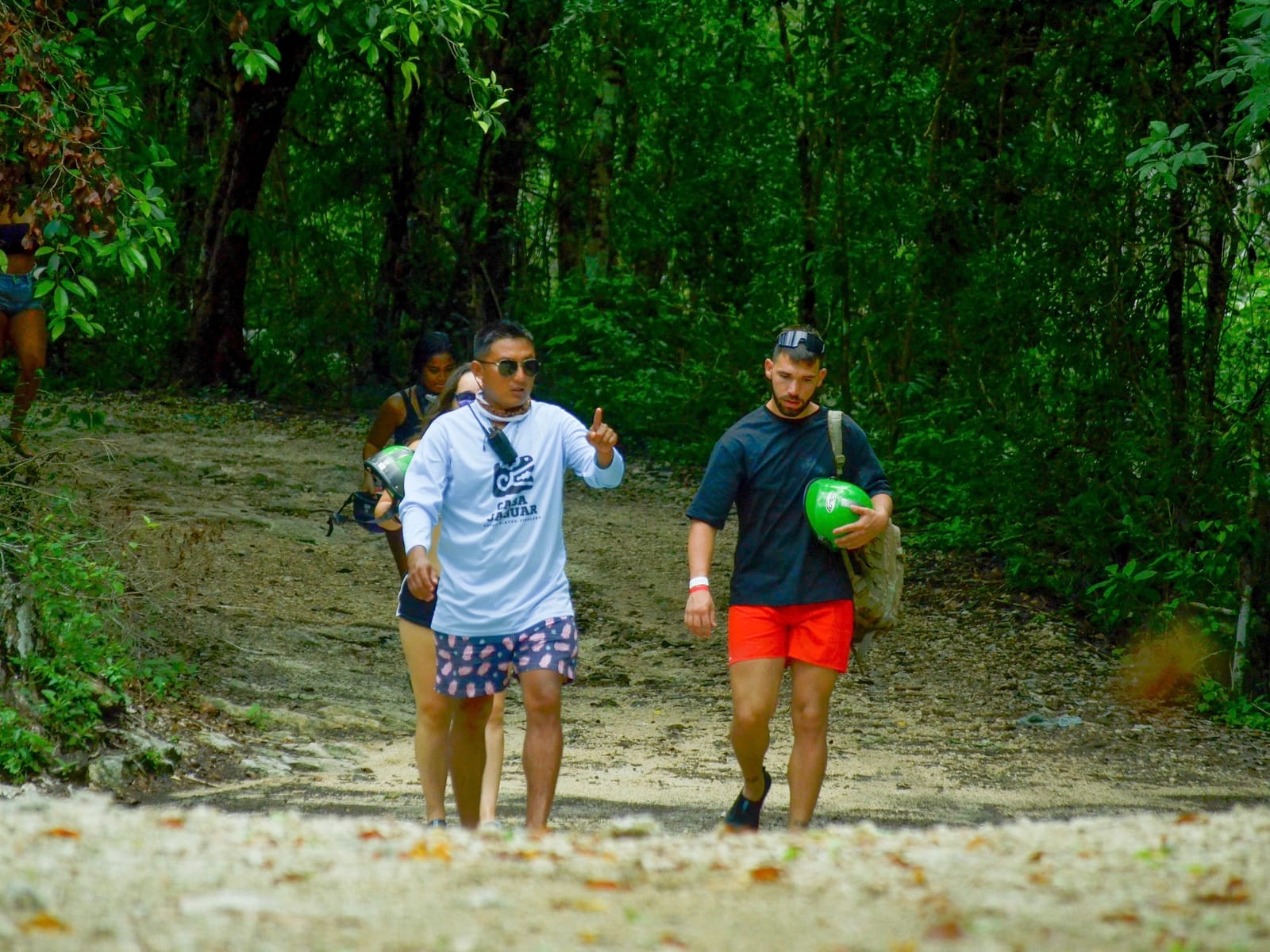 Guía de la selva indica el camino a los visitantes, que llevan sus cascos