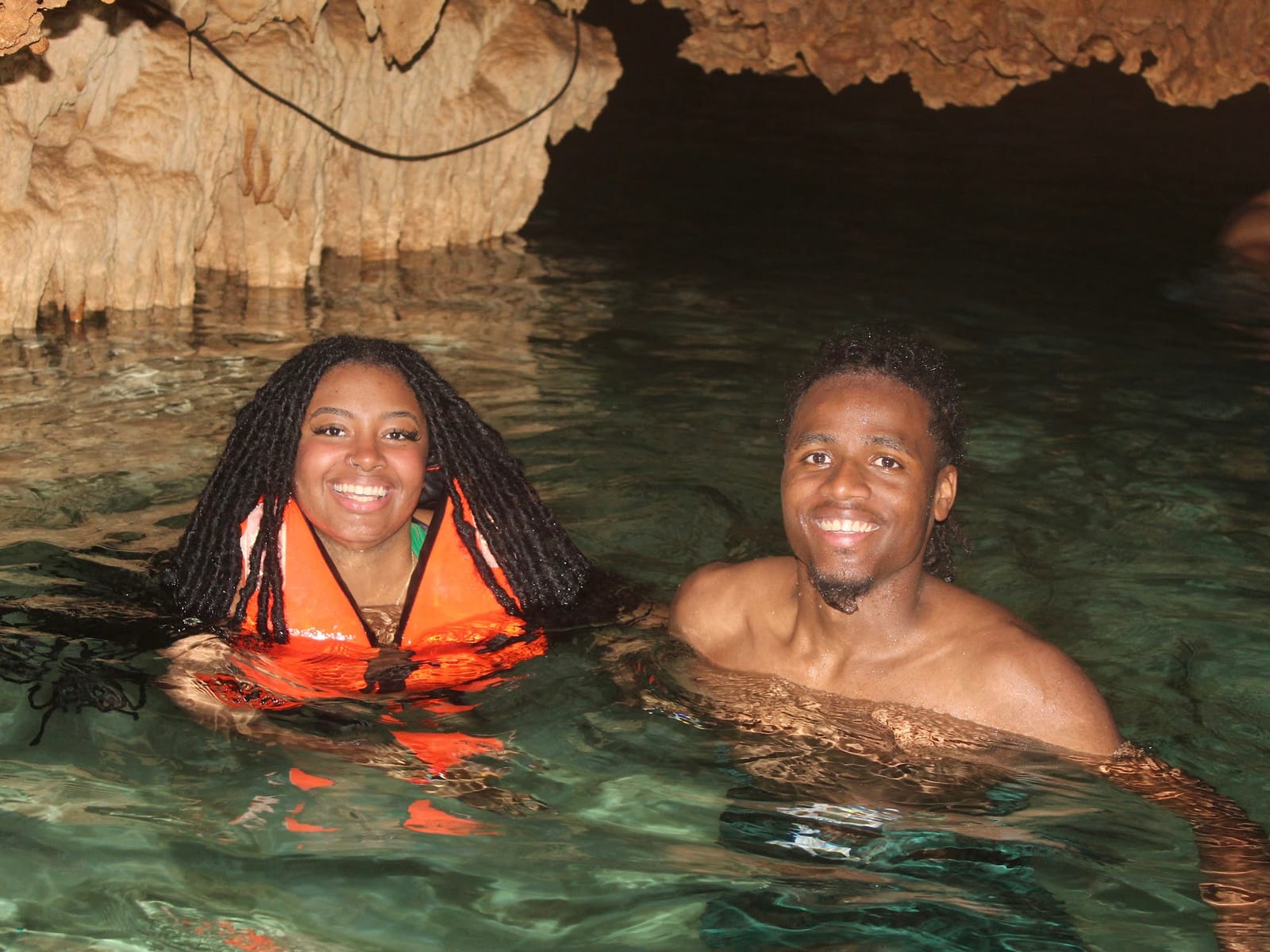 Pareja sonriente en el agua cristalina del Cenote Alux