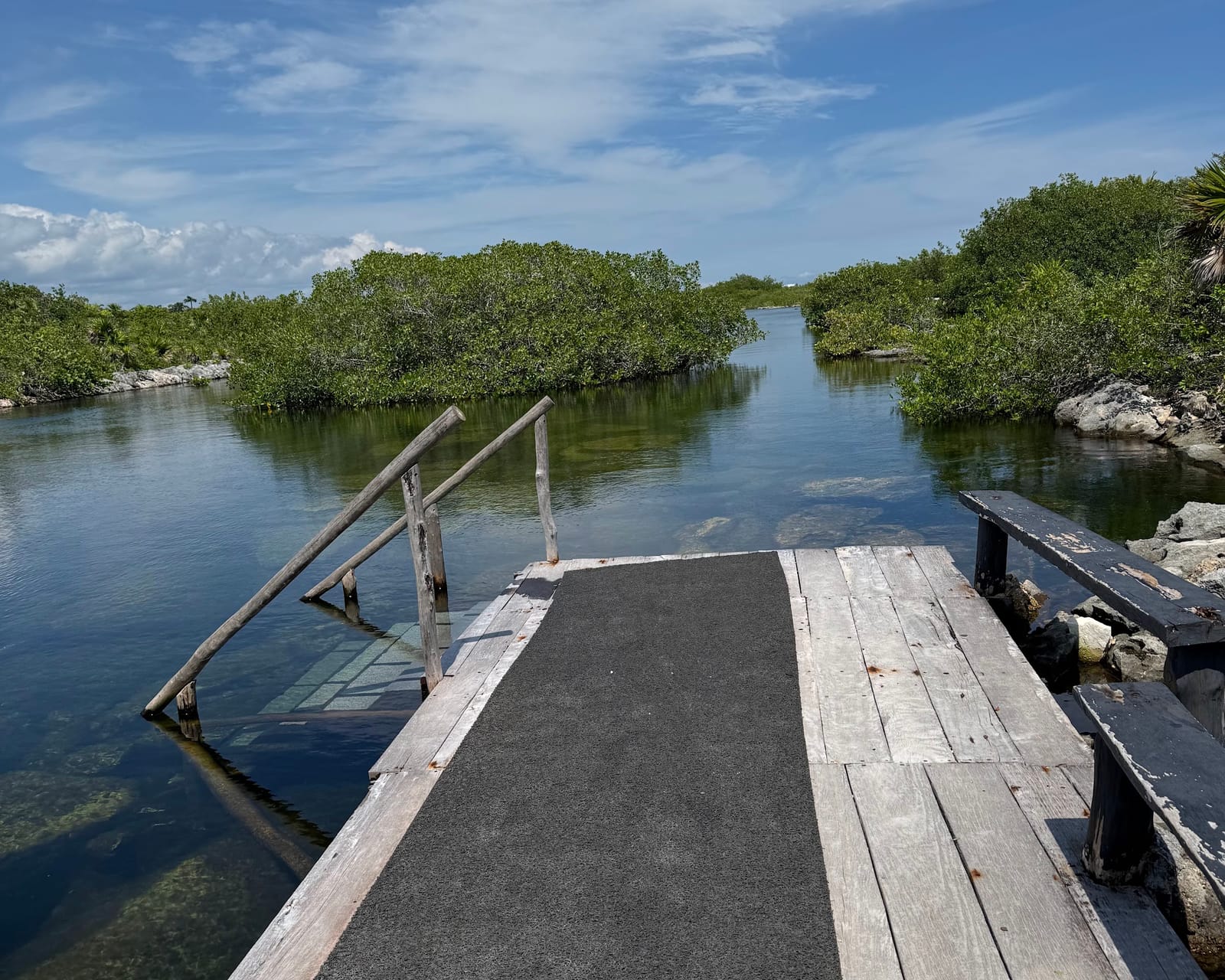 Muelle de madera con escalera para entrar al agua en la Laguna Yal-Kú